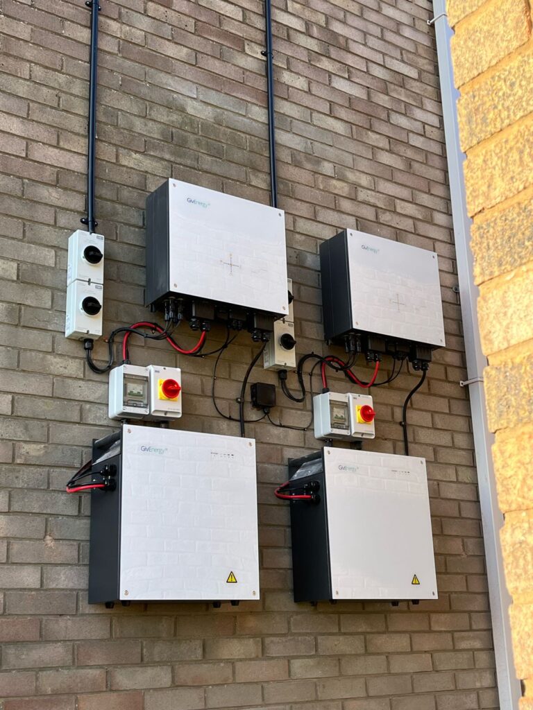 GivEnergy batteries and inverters fitted on a house wall to add a battery to existing solar panels