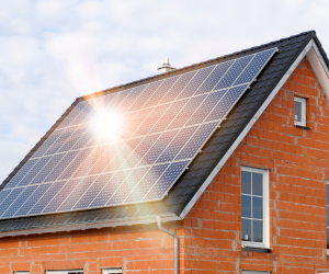 The sun reflecting off of solar panels on a house roof